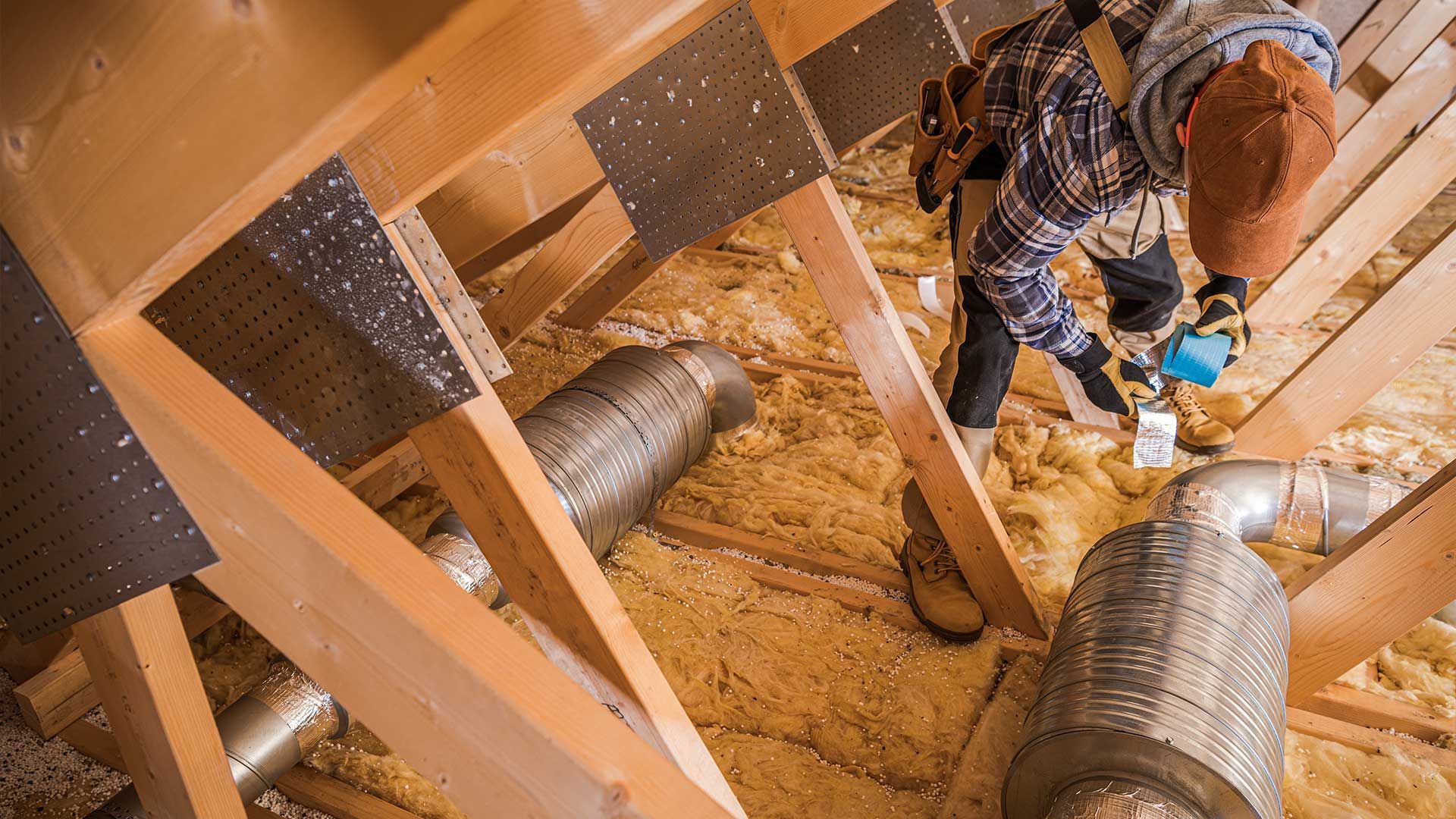 A man is working on the attic of a house.