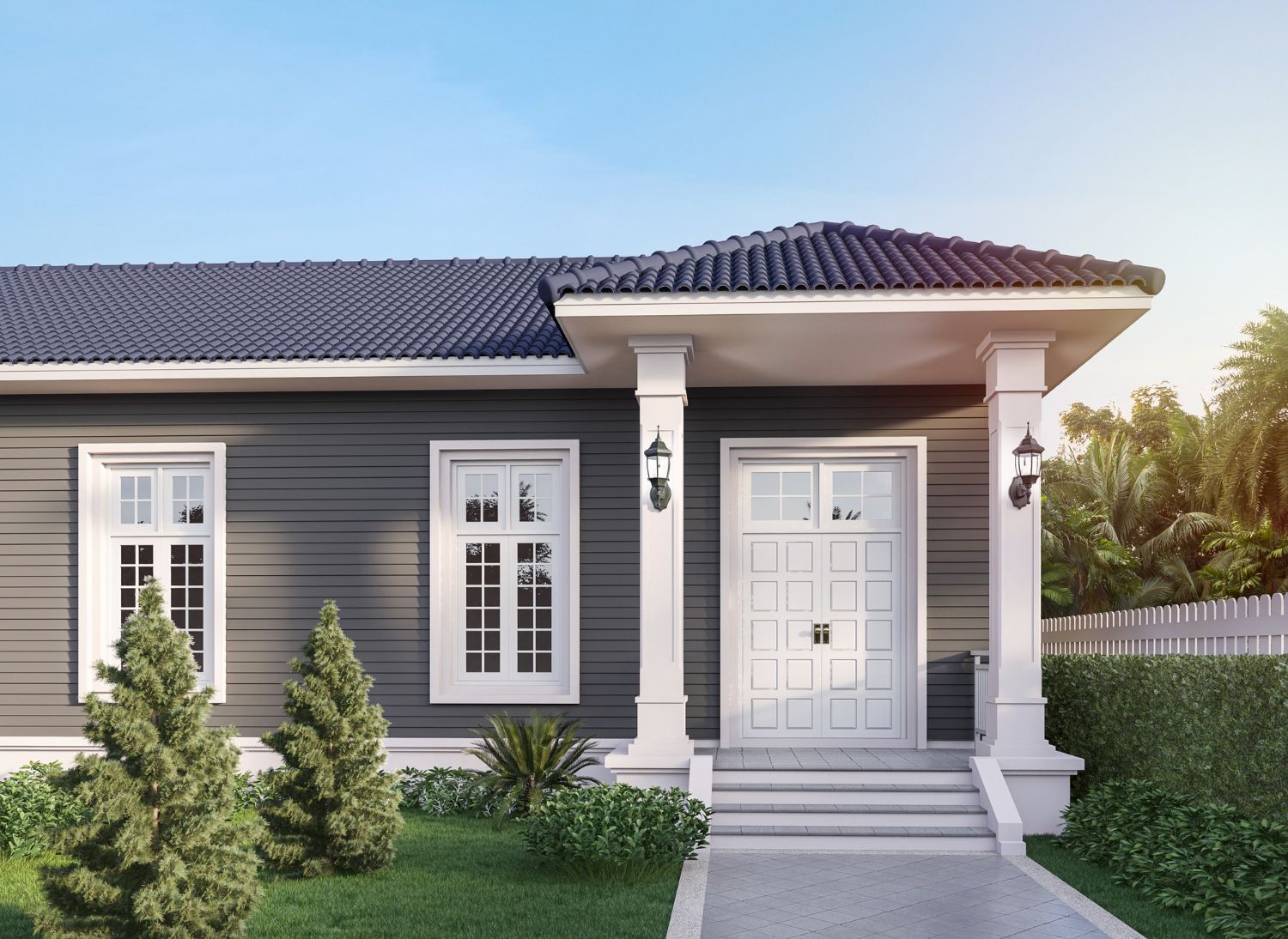 A gray single-story house with a dark tiled roof, white trim, two front windows, and a white door with stairs and columns.